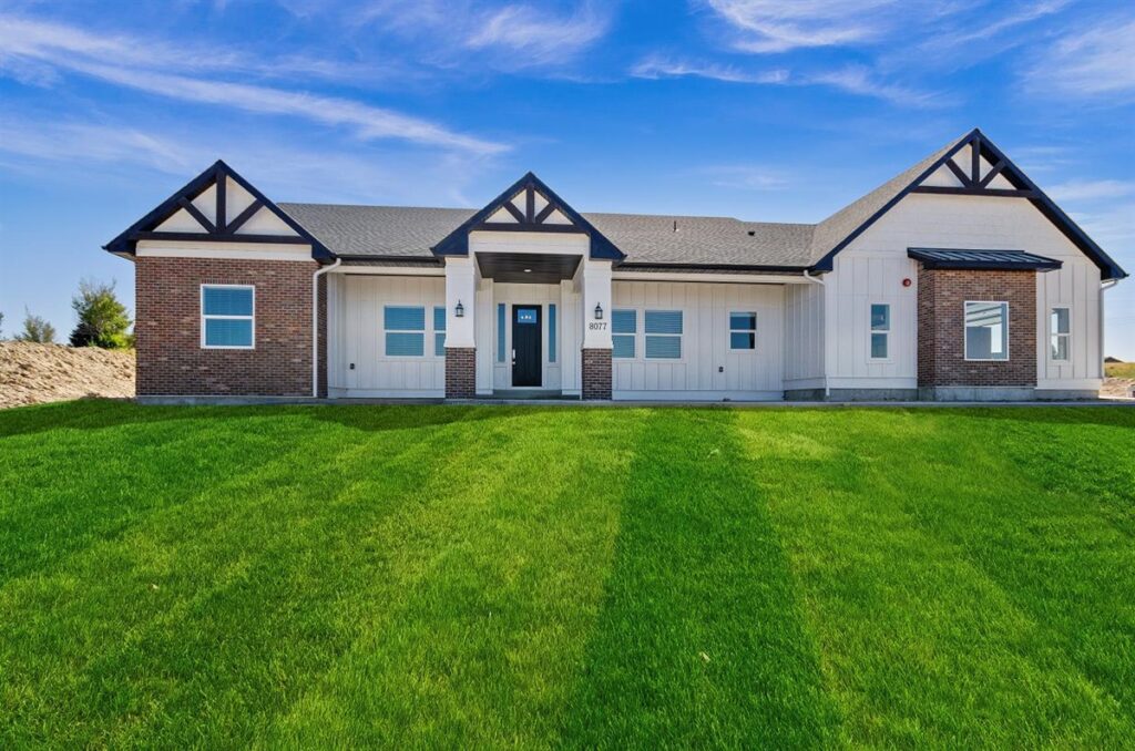 modern white and brick house with large front yard