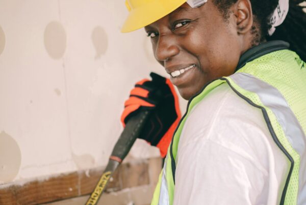 A female contractor smiling over her shoulder as she works on residential demolition.