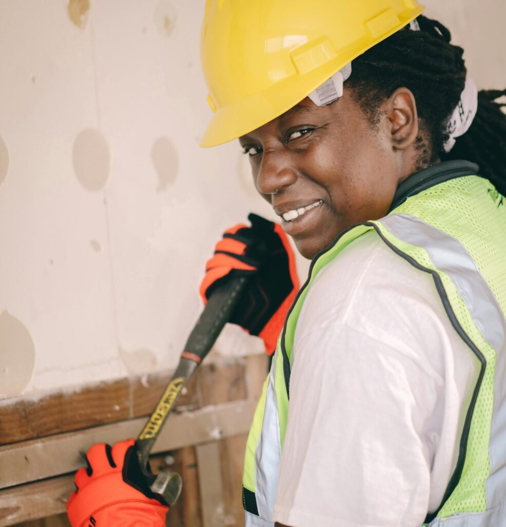 A female contractor smiling over her shoulder as she works on residential demolition.